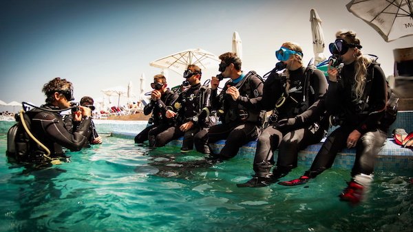 Group of divers ready to jump to the pool